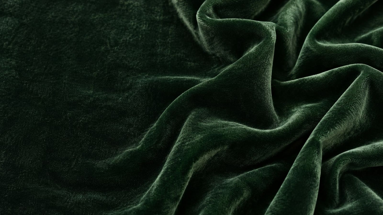 Deep forest-green velvet with soft folds and a rich, light-catching pile
